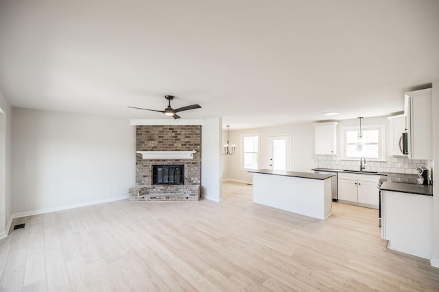 kitchen with pendant lighting, tasteful backsplash, a kitchen island, and white cabinets