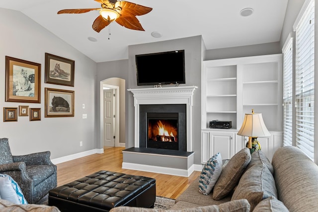 living room featuring lofted ceiling, light hardwood / wood-style flooring, and ceiling fan