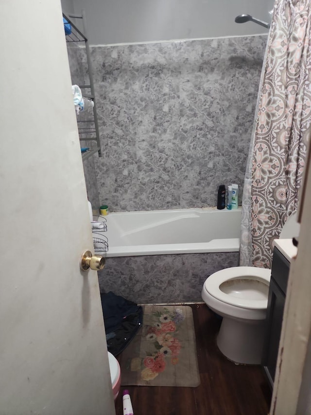 full bathroom with shower / bath combo, hardwood / wood-style floors, vanity, and toilet