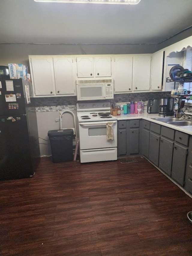 kitchen with dark hardwood / wood-style floors, white cabinetry, sink, gray cabinetry, and white appliances