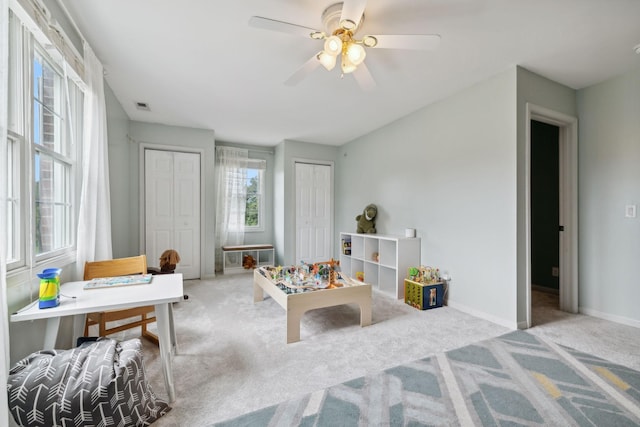 playroom with light carpet and ceiling fan