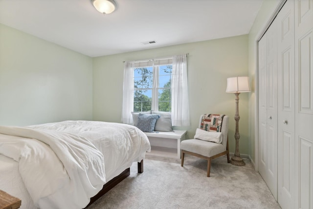 bedroom featuring light colored carpet and a closet