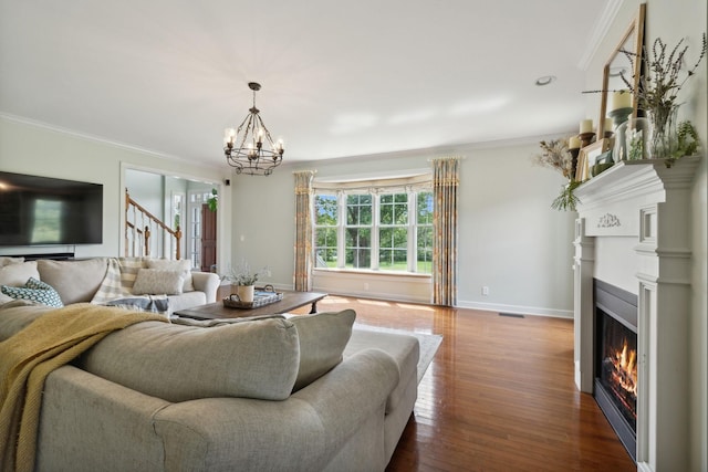 living room featuring crown molding, wood-type flooring, and a chandelier