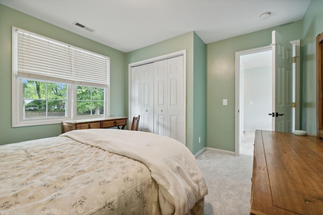 bedroom featuring light carpet and a closet