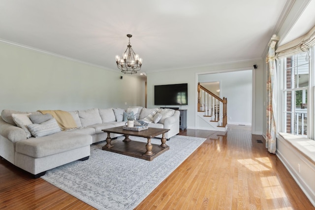 living room featuring crown molding, hardwood / wood-style floors, and an inviting chandelier