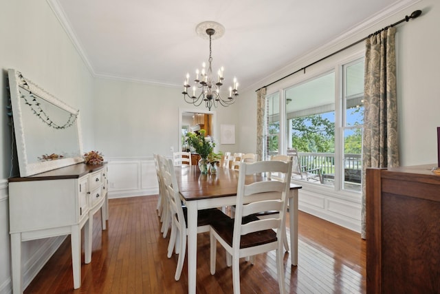 dining space featuring wood-type flooring, ornamental molding, and a chandelier