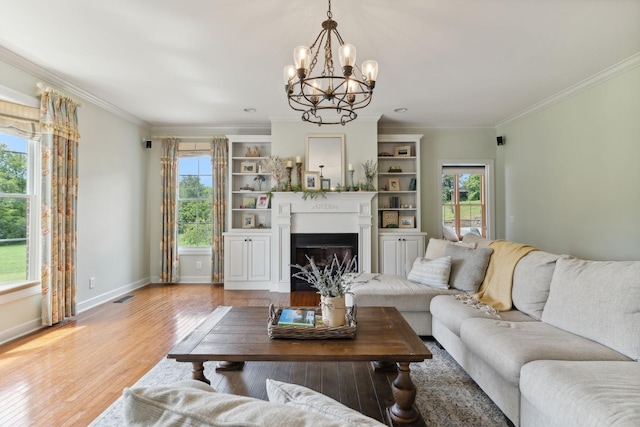 living room featuring ornamental molding, plenty of natural light, and light hardwood / wood-style flooring