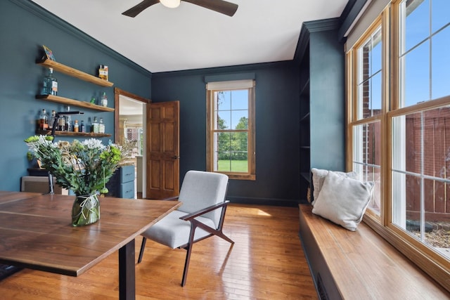 home office featuring ornamental molding, bar, ceiling fan, and light wood-type flooring