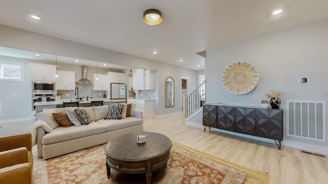 living room with sink and light hardwood / wood-style floors