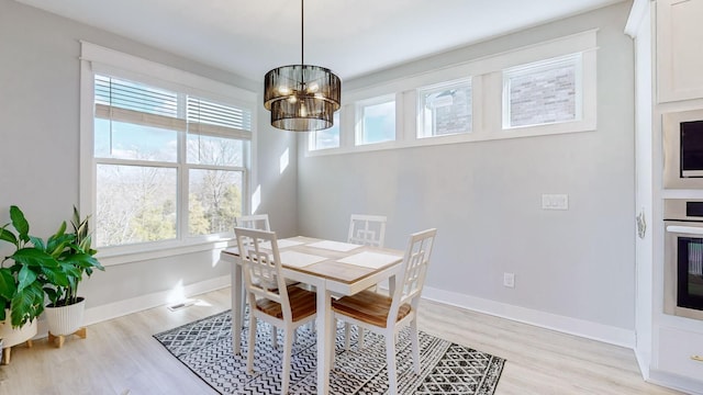 dining room featuring an inviting chandelier and light wood-type flooring