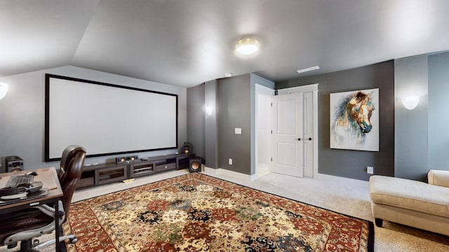 carpeted home theater with vaulted ceiling