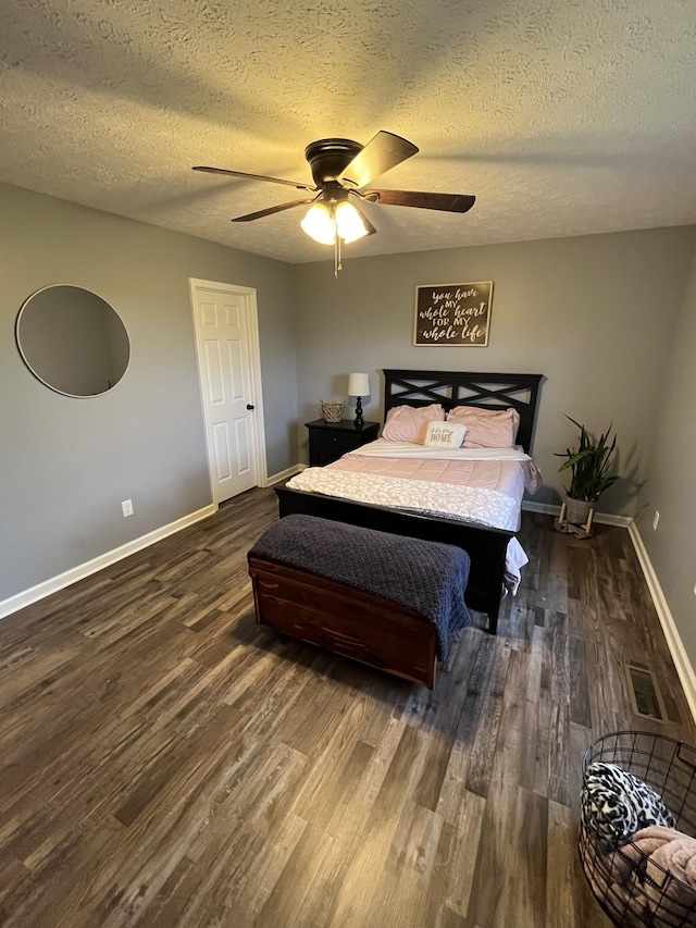 bedroom with a textured ceiling, dark hardwood / wood-style floors, and ceiling fan