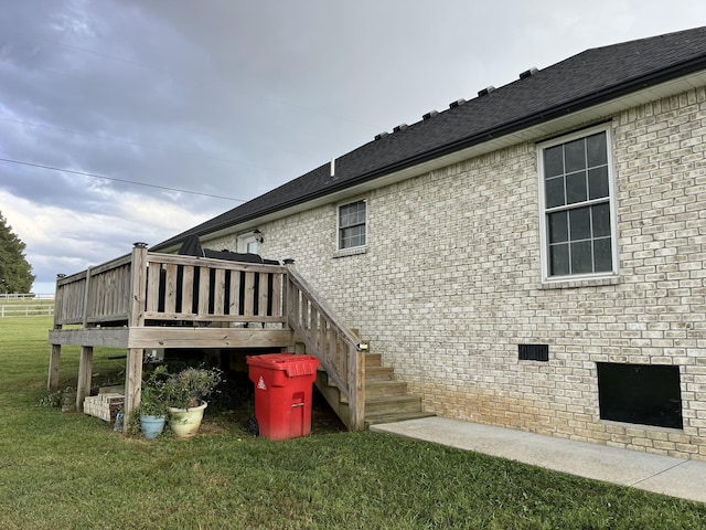 view of side of property with a lawn and a deck