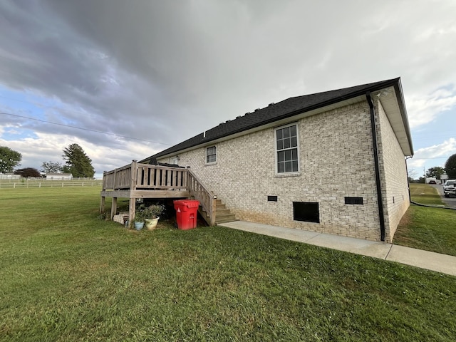 view of side of property featuring a wooden deck and a yard