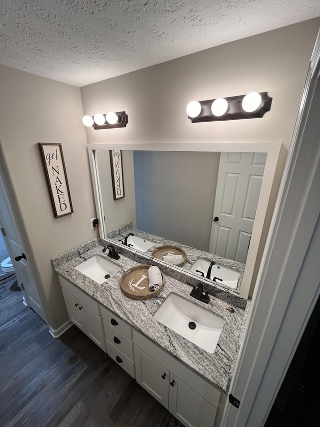 bathroom featuring wood-type flooring, a textured ceiling, and vanity