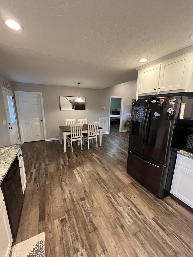 kitchen featuring white cabinetry, dark hardwood / wood-style floors, pendant lighting, light stone countertops, and black appliances