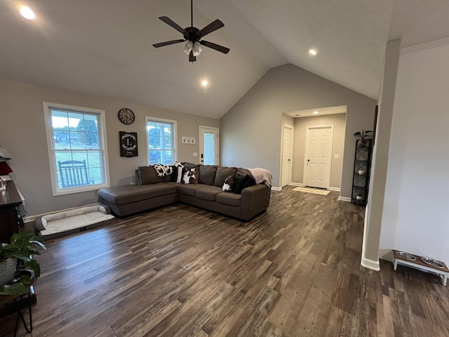 living room featuring dark wood-type flooring, ceiling fan, and vaulted ceiling