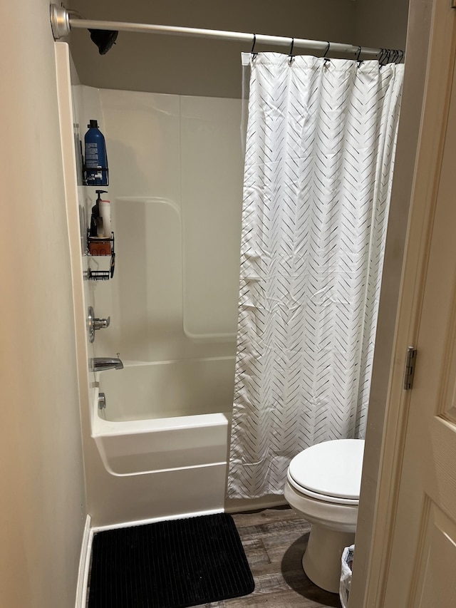 bathroom with shower / tub combo, hardwood / wood-style flooring, and toilet