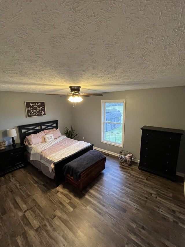 bedroom featuring dark hardwood / wood-style floors, a textured ceiling, and ceiling fan