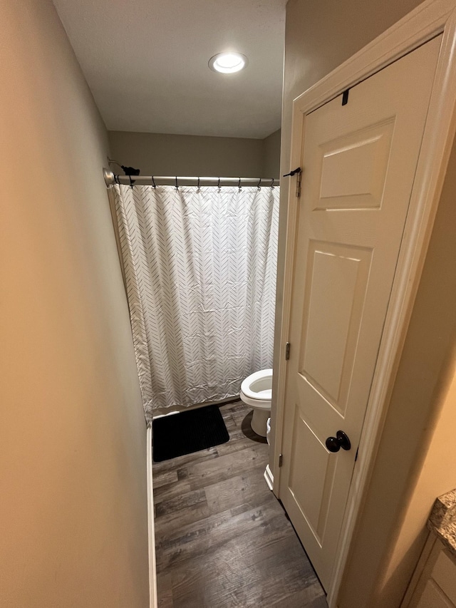 bathroom featuring a shower with curtain, toilet, and hardwood / wood-style floors