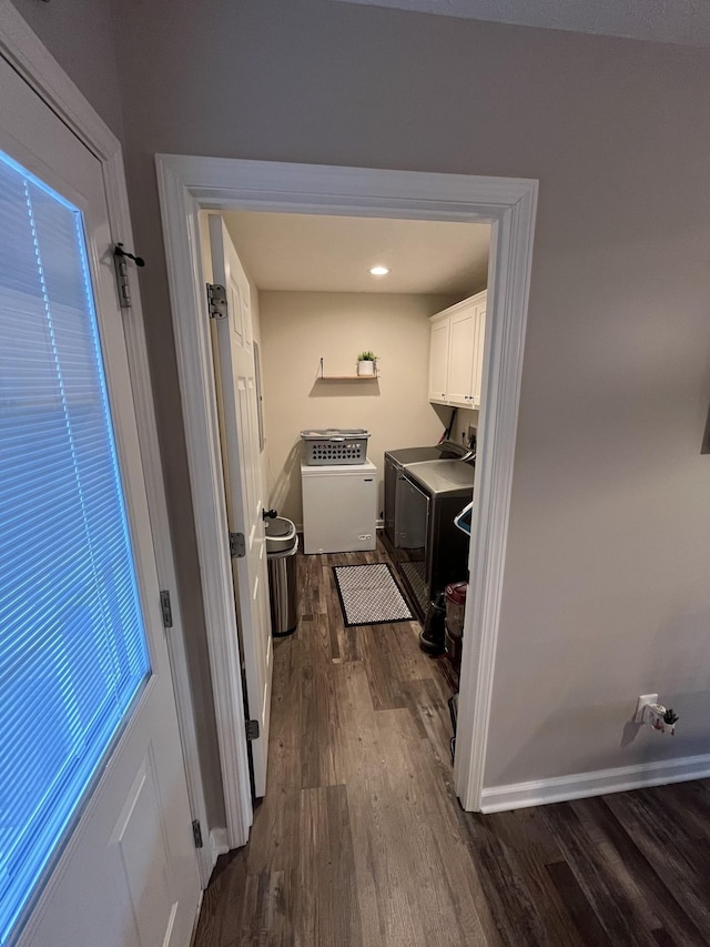 laundry room featuring cabinets, dark wood-type flooring, and independent washer and dryer