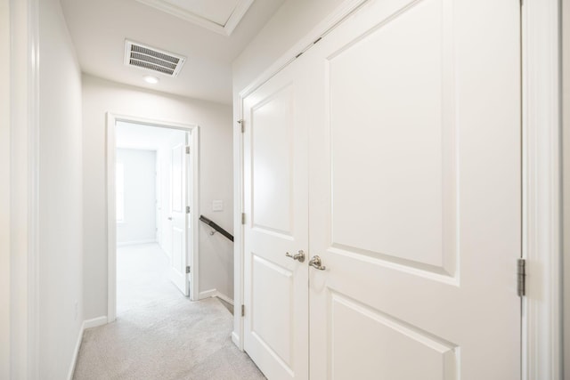 hallway featuring crown molding and light carpet