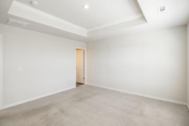 carpeted empty room featuring a raised ceiling and ornamental molding