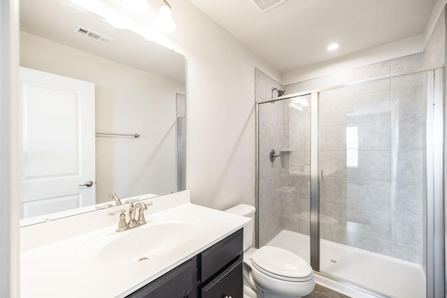 bathroom featuring vanity, toilet, and an enclosed shower