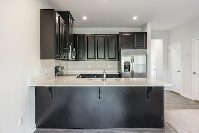 kitchen with sink, a breakfast bar, kitchen peninsula, and appliances with stainless steel finishes