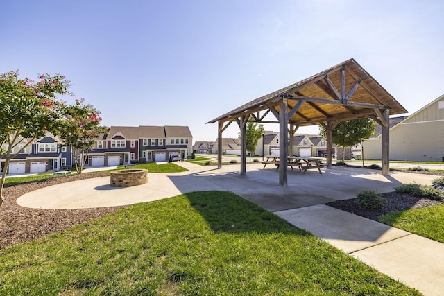 surrounding community featuring a gazebo, a lawn, and a fire pit