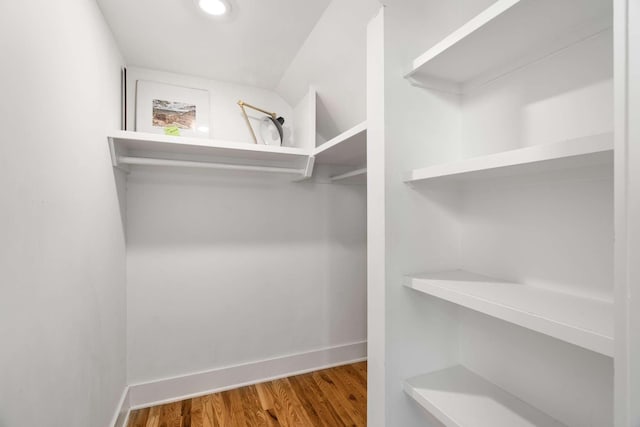 spacious closet with lofted ceiling and hardwood / wood-style floors