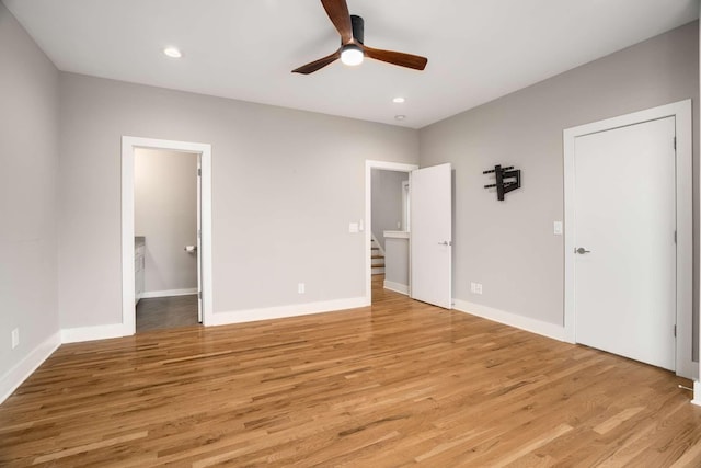 unfurnished bedroom with ensuite bath, ceiling fan, and light wood-type flooring