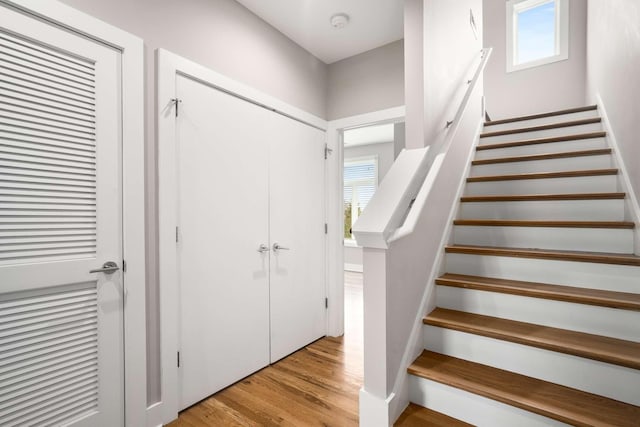 stairs with hardwood / wood-style flooring and a healthy amount of sunlight