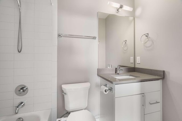 full bathroom featuring vanity, tiled shower / bath, and toilet