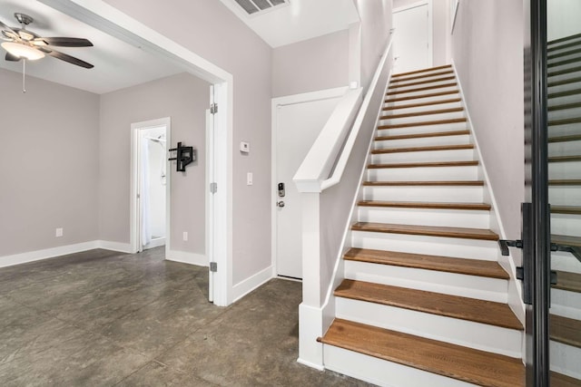 stairs featuring ceiling fan