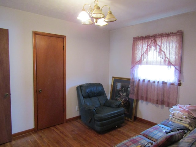 sitting room featuring an inviting chandelier and hardwood / wood-style floors