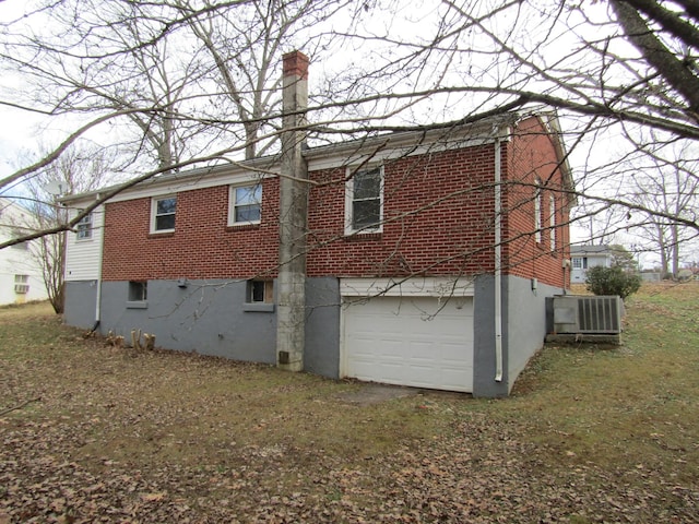 rear view of house with a garage and central air condition unit