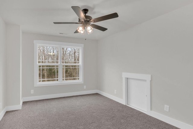 carpeted spare room with ceiling fan