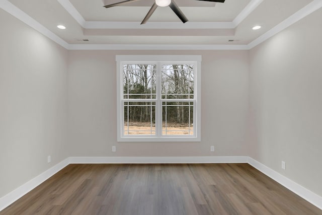 unfurnished room featuring hardwood / wood-style floors, ornamental molding, and a raised ceiling