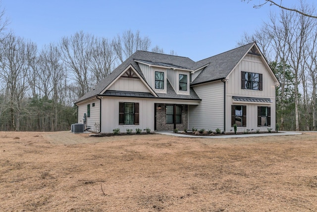 view of front of house with central AC unit and a front lawn