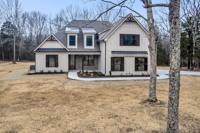 modern inspired farmhouse with a front lawn and covered porch