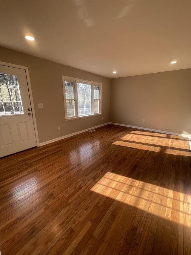 unfurnished room with recessed lighting, visible vents, baseboards, and dark wood-type flooring