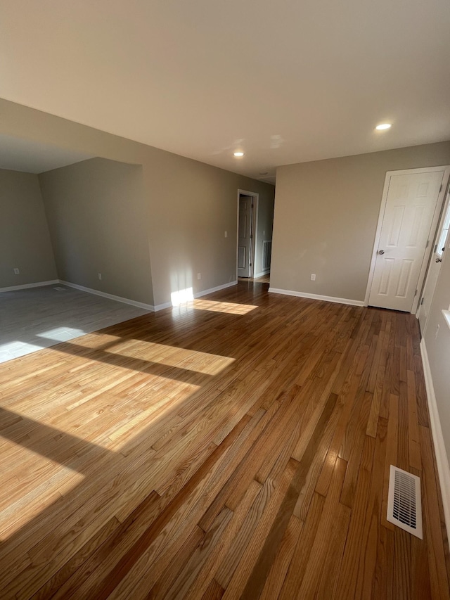 empty room featuring visible vents, recessed lighting, baseboards, and dark wood-style flooring