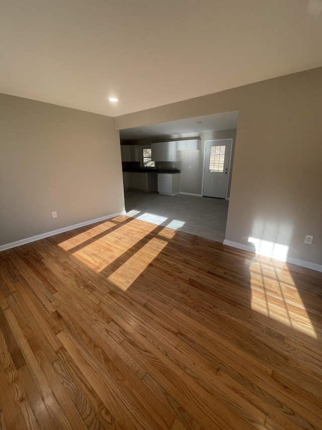 unfurnished living room featuring baseboards and wood finished floors