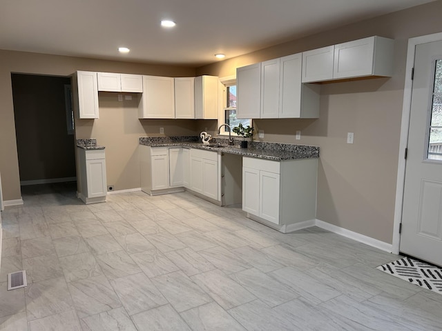 kitchen with recessed lighting, baseboards, visible vents, and a sink