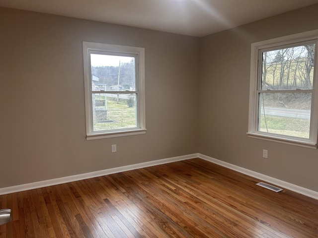 unfurnished room with baseboards, visible vents, and a wealth of natural light