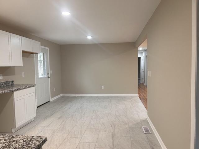 kitchen with recessed lighting, dark stone counters, baseboards, and white cabinets