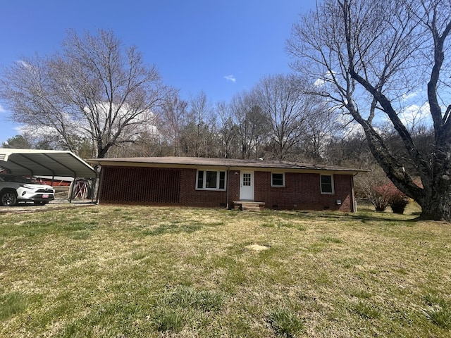 view of front of house with a detached carport, a front yard, brick siding, and crawl space