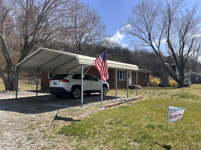 view of front of house featuring brick siding, a detached carport, and a front yard