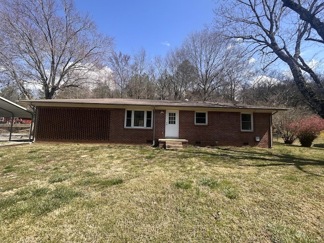 rear view of house featuring a yard, brick siding, and crawl space